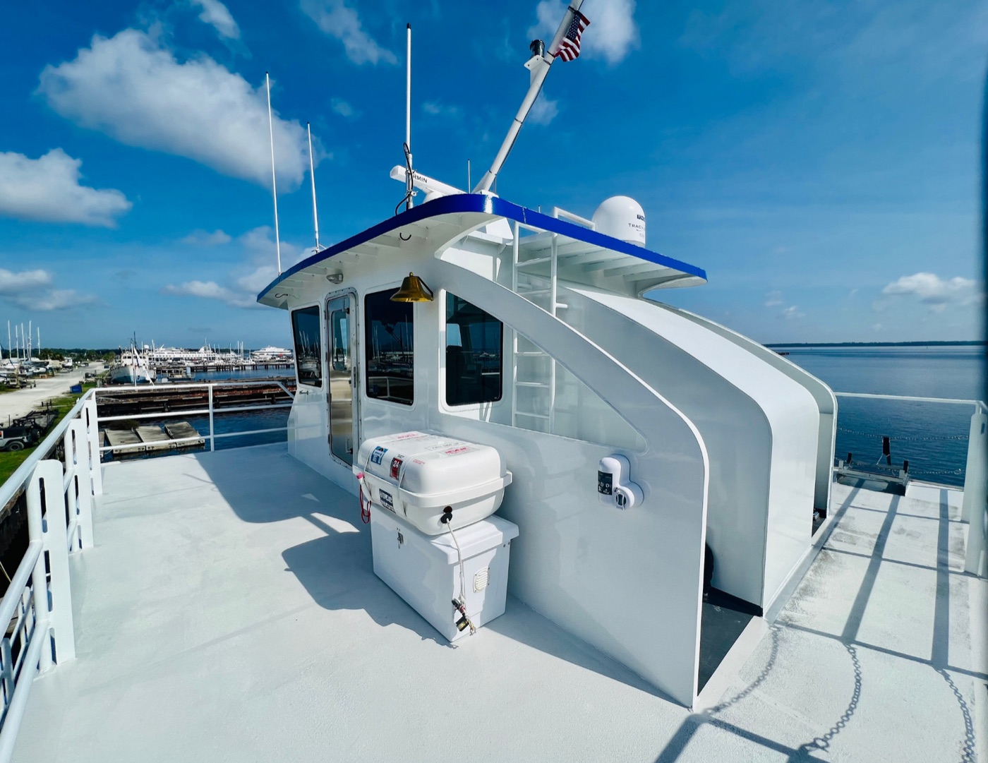 Upper deck of the Island Hot Shot at a marina under blue sky